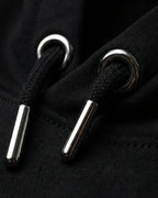 Detailaufnahme der hochwertigen Kordeln mit Metallenden am "No Problama" Hoodie in Schwarz.
