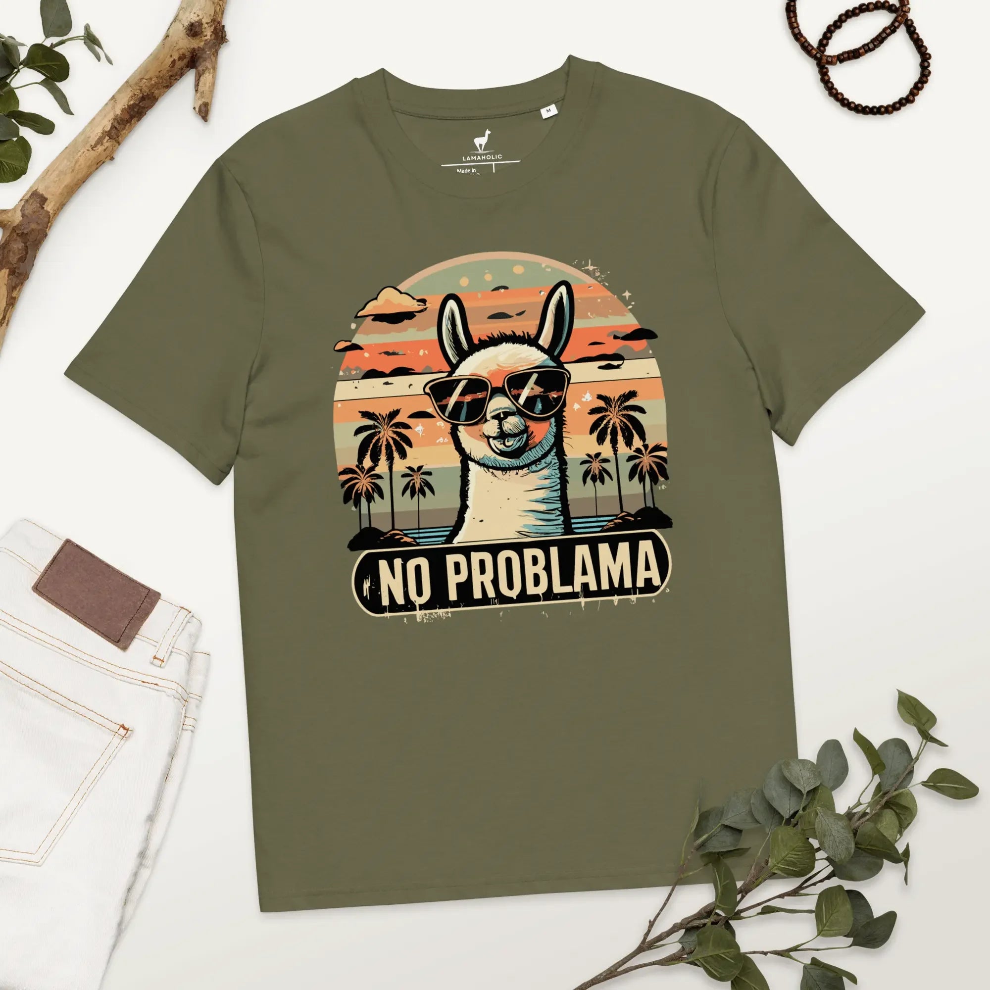 Lustiges Lama T-Shirt in Khaki mit "No Problama" Design, flach liegend auf einem Holztisch.
