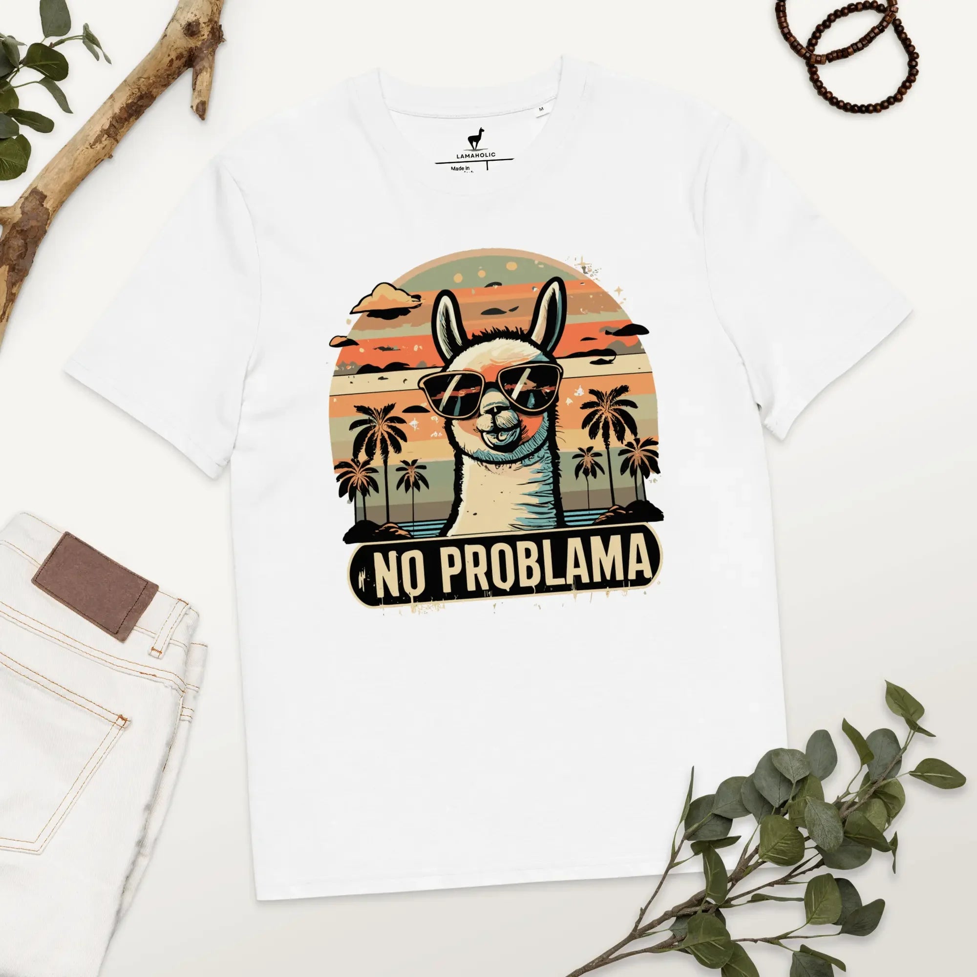 Lustiges Lama T-Shirt in Weiss mit "No Problama" Design, flach liegend auf einem Holztisch.