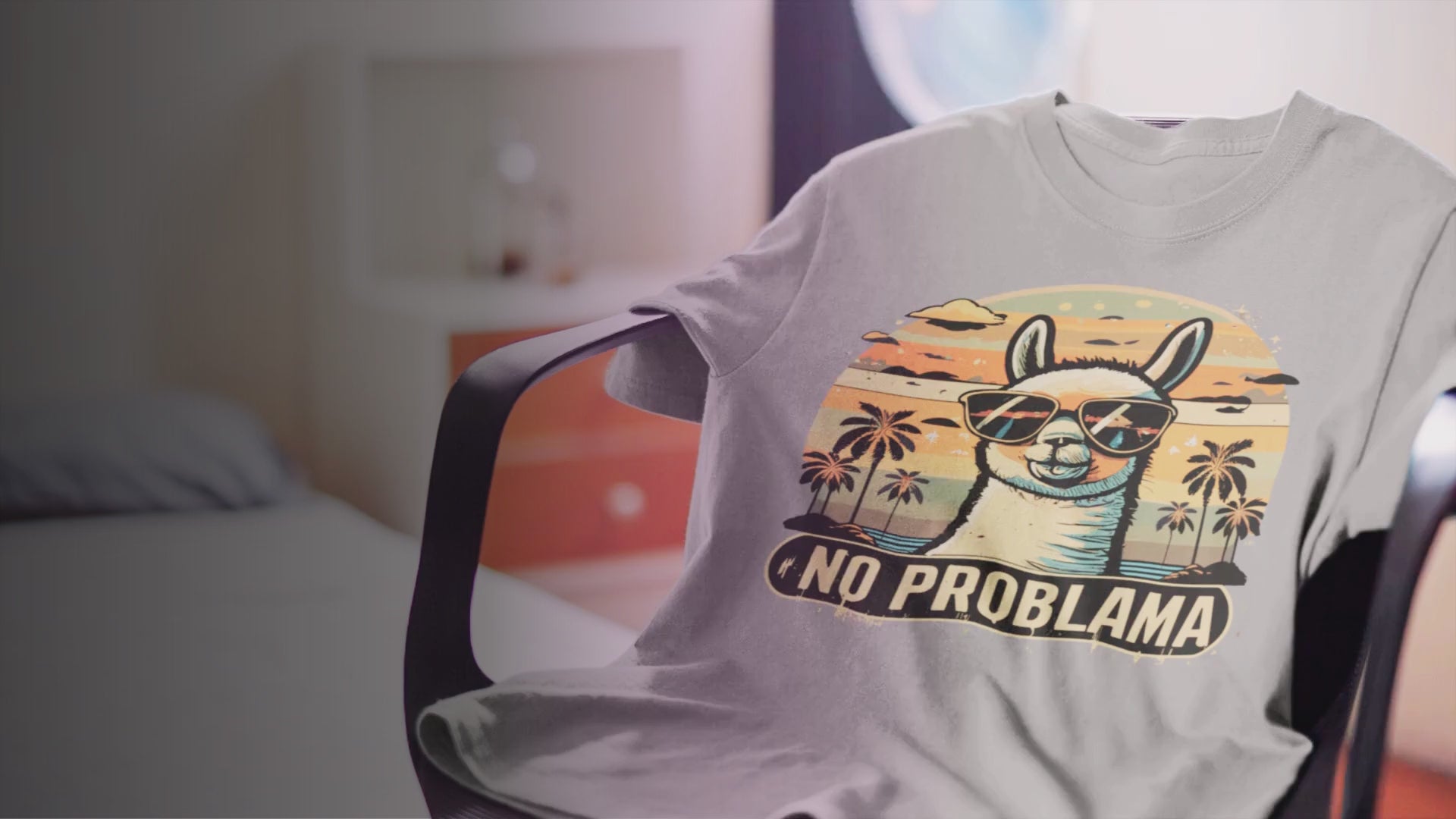 Das No Problama T-Shirt von Lamaholic liegt auf einem Drehstuhl im Hintergrund leicht verschwommen sieht man ein gemütliches helles Zimmer
